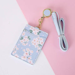 Leather card holder with floral motifs and retractable lanyard, suitable for women.